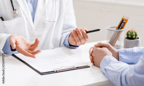 Puzzled doctor talking with poor senior patient  close up