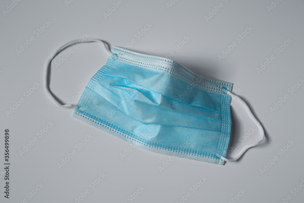 Disposable face mask on light background, top view. Protective measures during coronavirus quarantine Disposable face mask on light background, top view. Protective measures during coronavirus quarantine