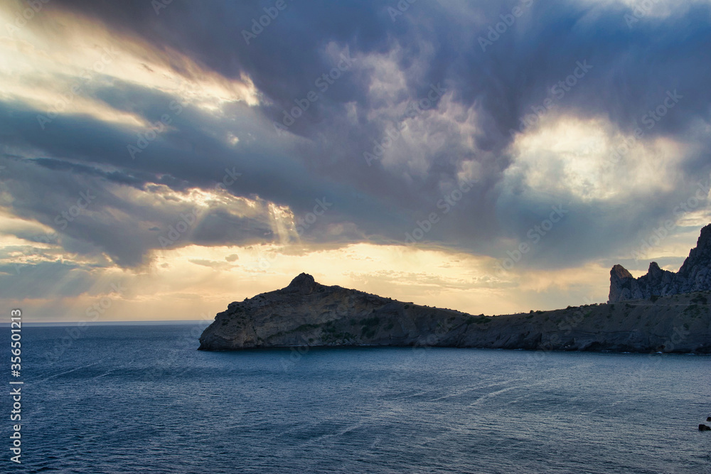 Mountain in the form of a dolphin on the black sea in Crimea. Cape Kapchik in the Black Sea near the village of Novy Svet sunny summer day. Natural colors and light, summer nature background concept.