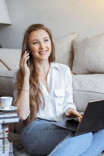 Young girl student bisinesswoman spend time at home working and studying and calling on mobile phone photo