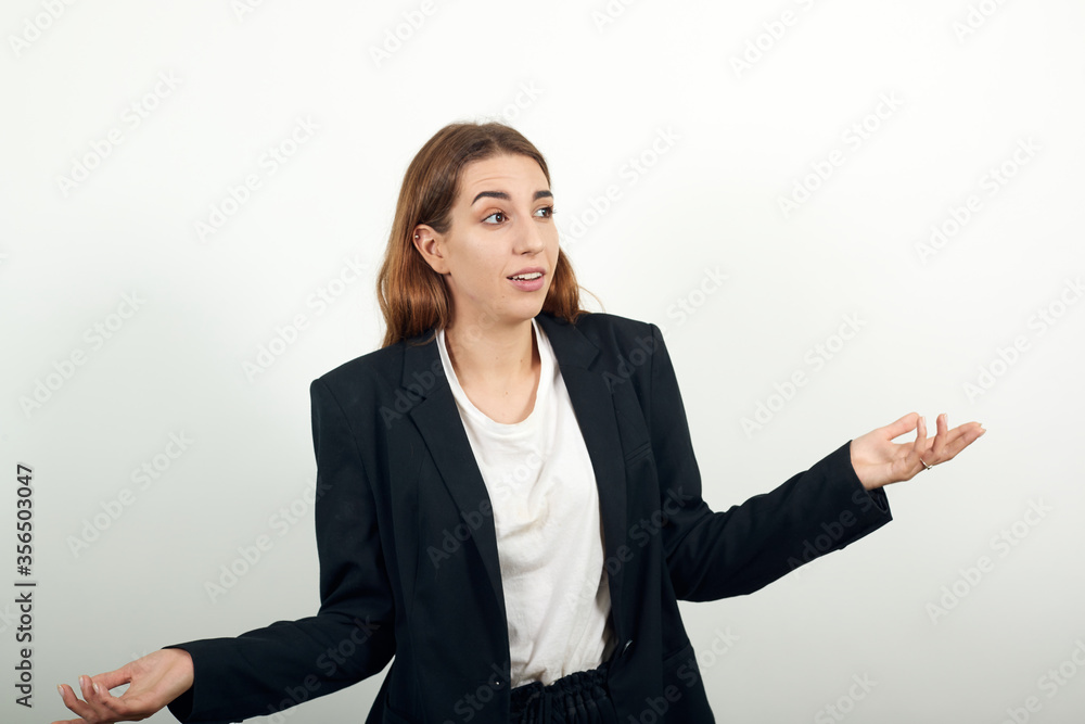 Wide open arms, incredulity, doubt beautiful woman. Is surprised spread palms, mimic and facial expressions. Young attractive woman with brown hair in a light t-shirt, black jacket on white background Wide open arms, incredulity, doubt beautiful woman. Is surprised spread palms, mimic and facial expressions. Young attractive woman with brown hair in a light t-shirt, black jacket on white background