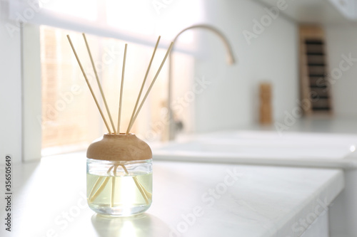 Aromatic reed air freshener on white table indoors. Space for text