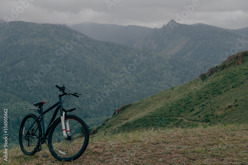 Горный велосипед в гора, на заднем плане скалы и облака.