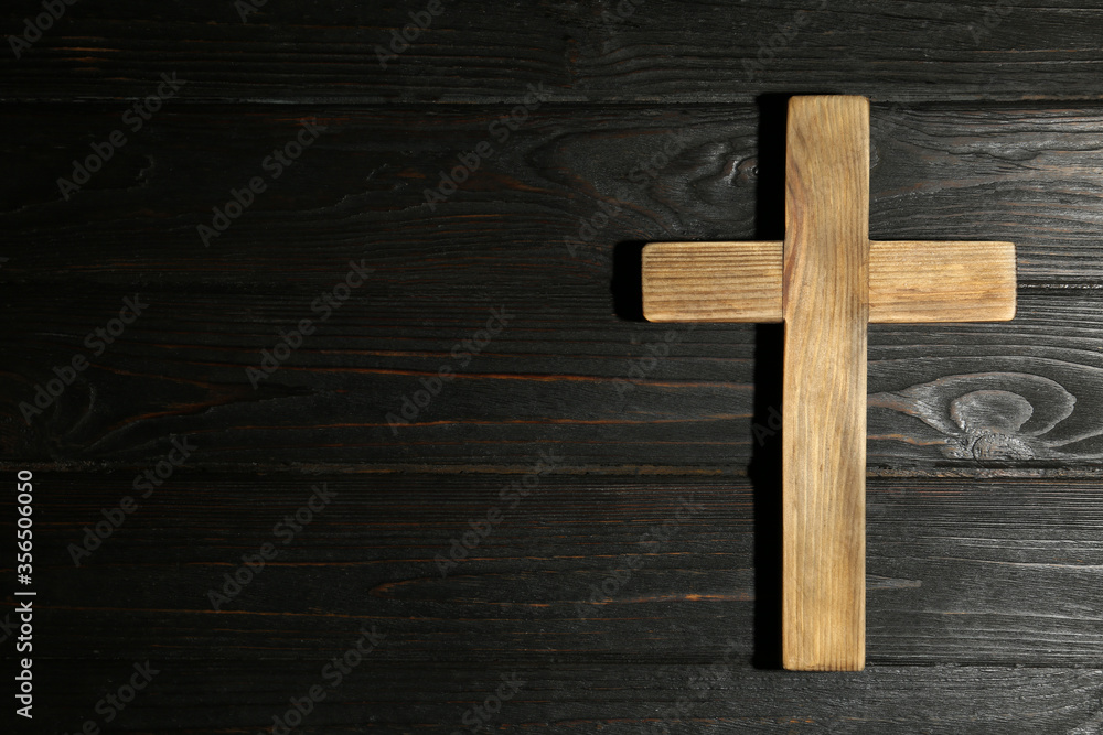 Christian cross on wooden background, top view with space for text. Religion concept