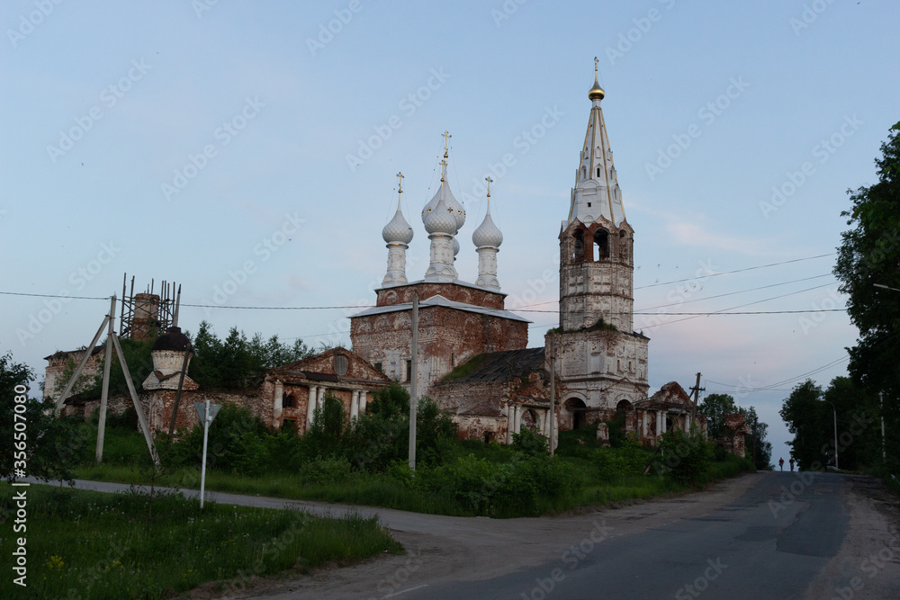 Country landscape with old white dome church in summer evening