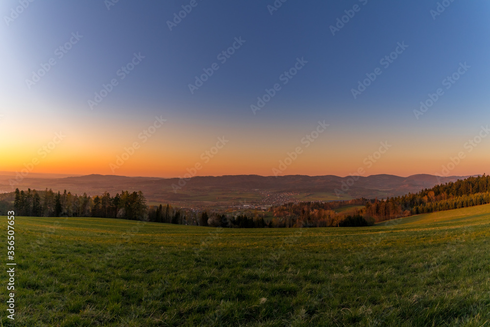 Sunset on a mountainous landscape with a village lying under the mountains Zasova Czech Republic.