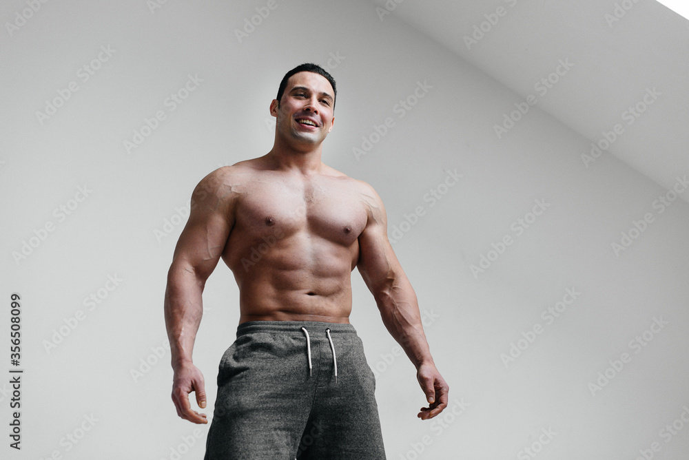 Sporty, sexy athlete smiling on a white background. Fitness Sporty, sexy athlete smiling on a white background. Fitness