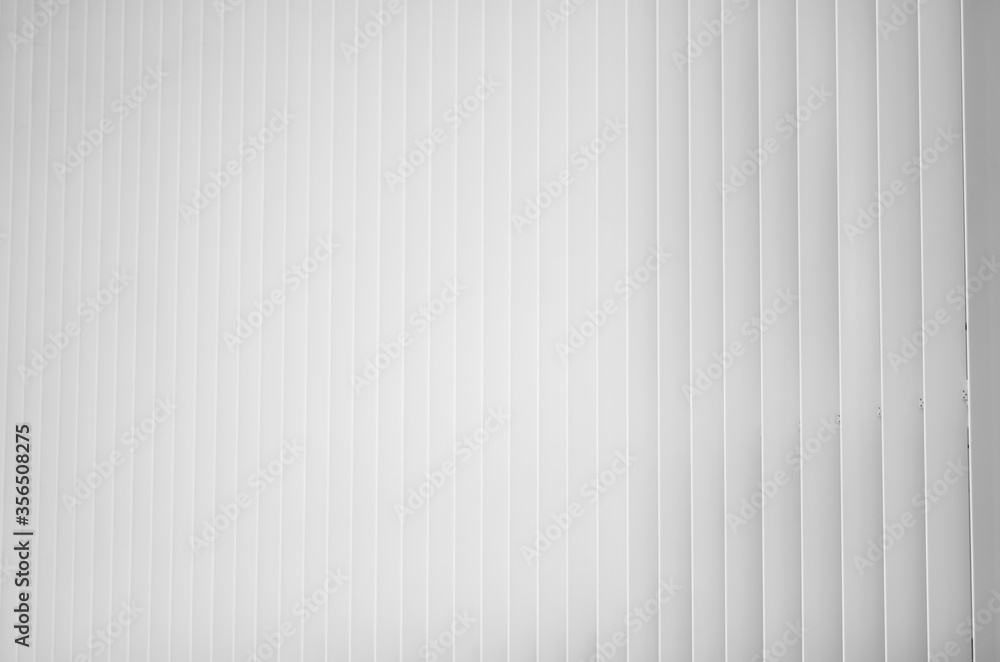 Fototapeta premium shades of white caused by light and perspective, on a building with a white railing, composed of vertical linear elements.