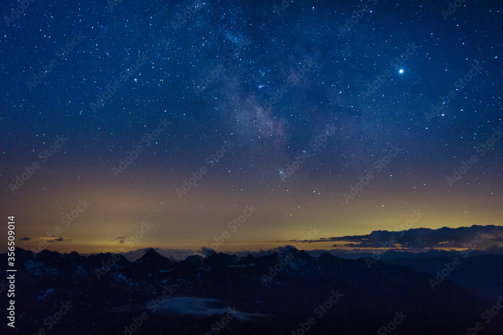 The Milky Way in the night sky over the Austrian Alps. View from the way to Grossglockner rock summit, Kals am Grossglockner, Austria