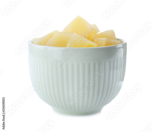 Pieces of delicious canned pineapple in bowl on white background