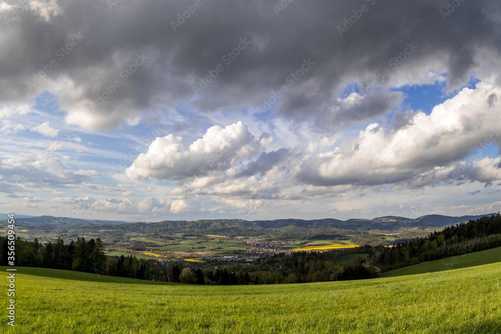 Landscape with lots of clouds in the mountainous area of the Beskydy Mountains during a sunny afternoon.