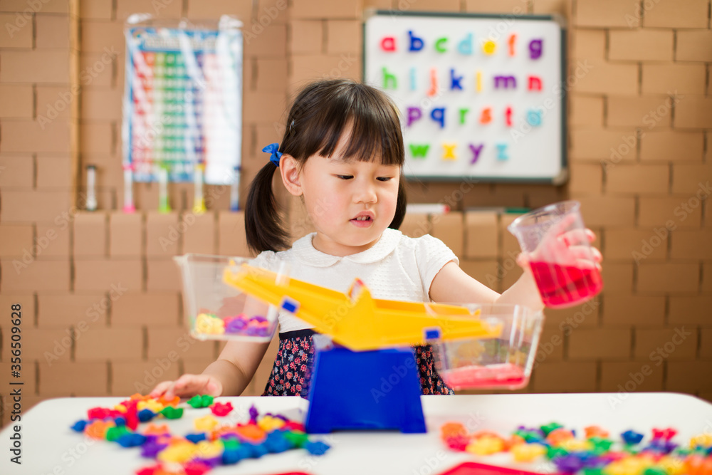 Fototapeta premium toddler girl play balance toy for homechooling