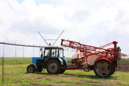 Modern agricultural equipment in field under cloudy sky