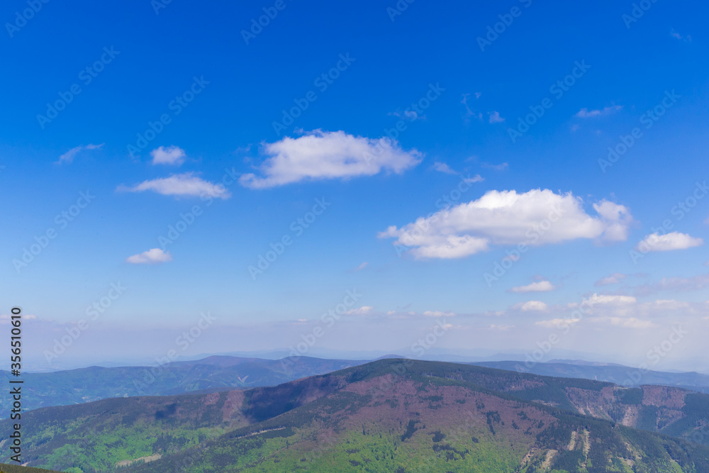Mountainous landscape and views of the hills during a sunny day with clouds in the sky.