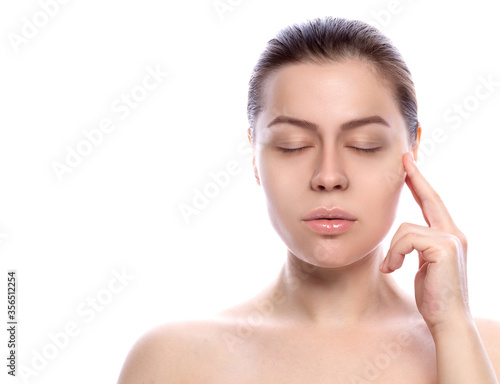  Portrait of a beautiful young woman with a headache. eyes are closed, finger touches temple. White background. Space for text.