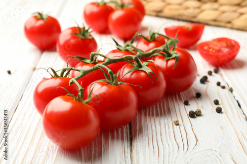 Tomatoes, pepper and basket on white wooden background, close up