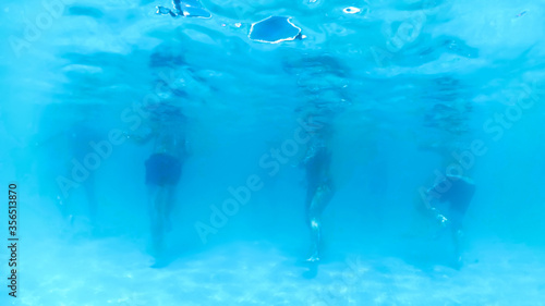 Underwater image of big crowd relaxing and having fun in outdoor swimming pool