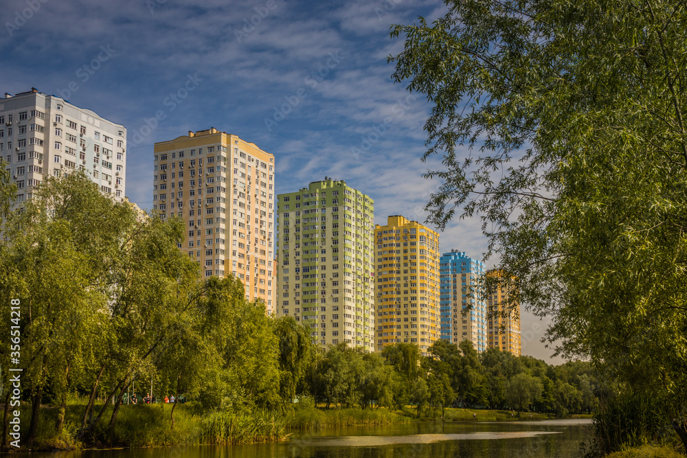 Landscape from sity park, Kyiv. Ukraine. Little river, hot summer, bright green trees and high buildings