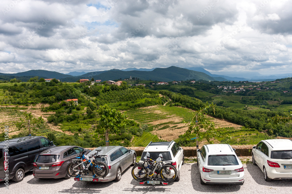 Naklejka premium Tourists in cars stopped to rest on top of a mountain against a blue sky with clouds