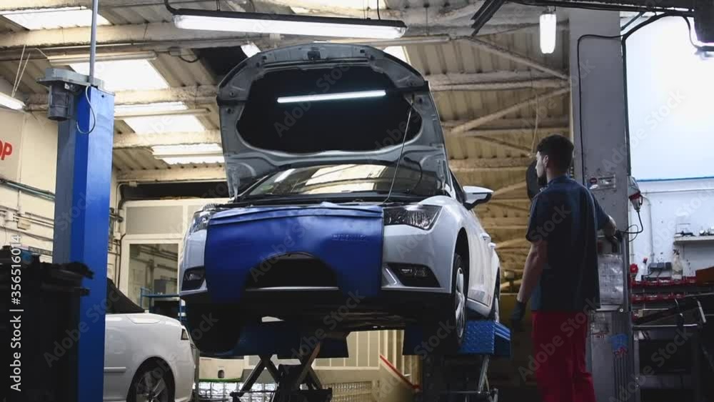 mechanic raising a car in workshop lift mechanic raising a car in workshop lift