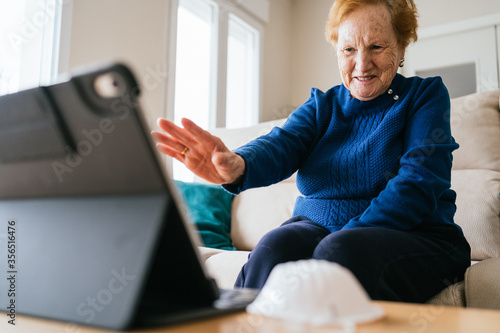 Senior woman communicating with friend during video chat on laptop