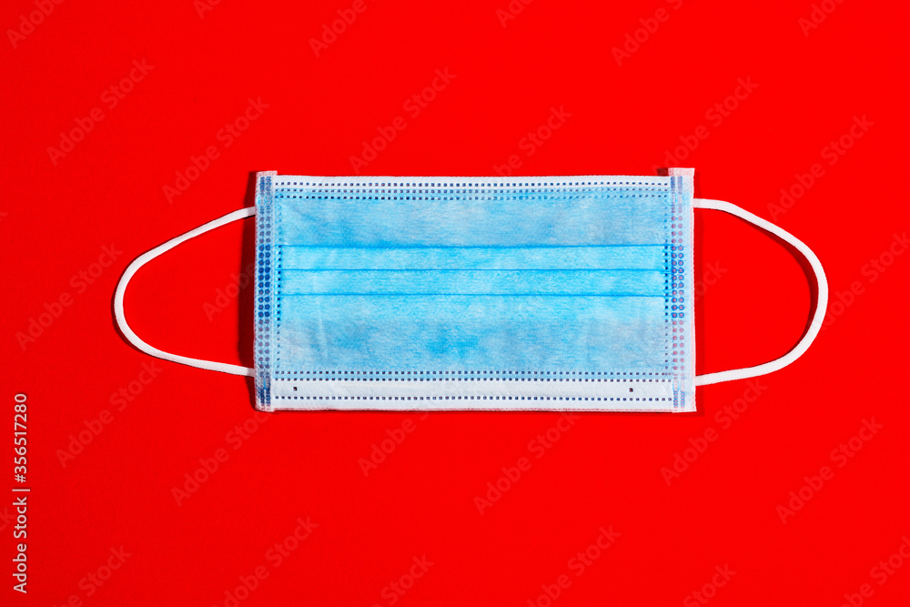 blue single-use mask for virus protection on red background blue single-use mask for virus protection on red background
