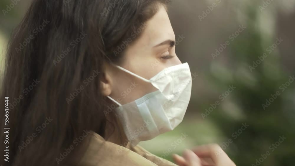Side view of young woman outdoors wearing medical face mask for protection of virus. Concept coronavirus pandemic, SARS, MERS, COVID-19, quarantine, isolation period. Side view of young woman outdoors wearing medical face mask for protection of virus. Concept coronavirus pandemic, SARS, MERS, COVID-19, quarantine, isolation period.
