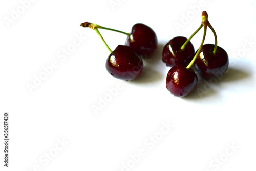 Fruits of ripe red and delicious cherries on a white background