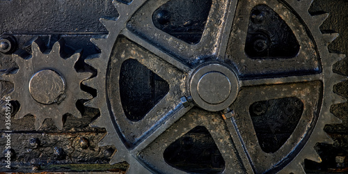 Shabby black gears of aged mechanism located in Port of San Esteban de Pravia in Spain