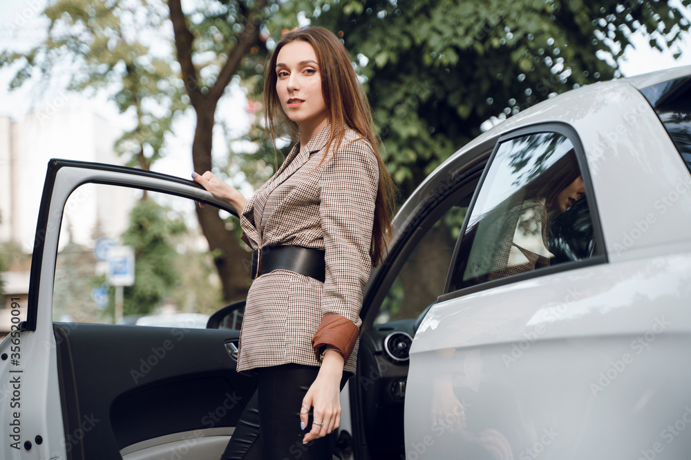 Beautiful young girl on the background of a luxury car Beautiful young girl on the background of a luxury car