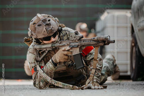 Soldier aiming airsoft gun during tactical game