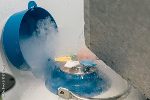 Nitrogen liquid splashing from a cryogenic tank container with frozen egg cells and embryos in fertility clinic