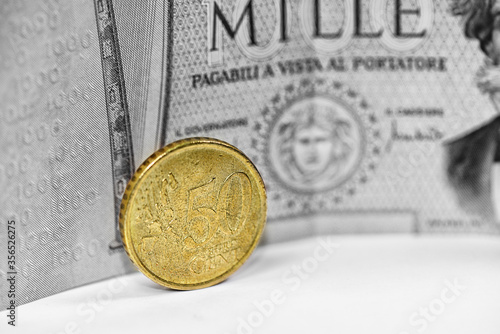 Conceptual image representing a comparison between a current euro currency and an old Italian lira banknote. Italian currency money that is no longer in use. photo