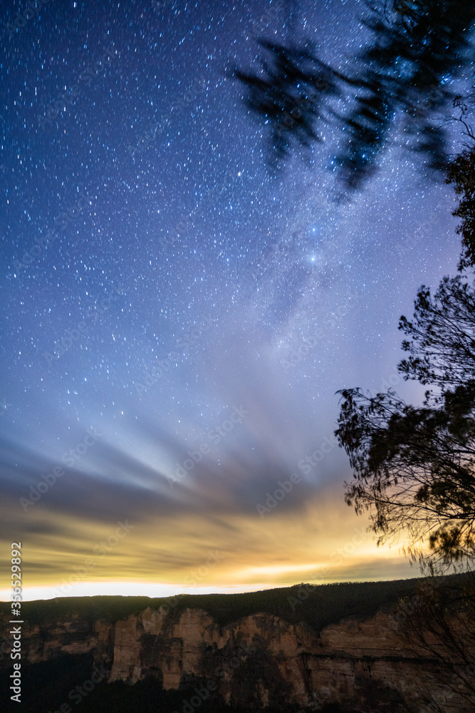 Fototapeta premium Milkyway rising over a mountain ridge with clouds on the horizon 