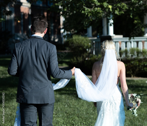 bride and groom walking in park