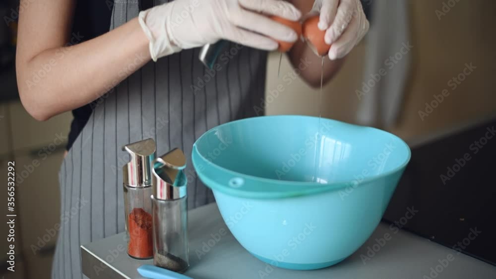 Close up chef hand braking an egg into a blue bowl then mix to prepare omelet cooking , 4k ProRes resolution Close up chef hand braking an egg into a blue bowl then mix to prepare omelet cooking , 4k ProRes resolution