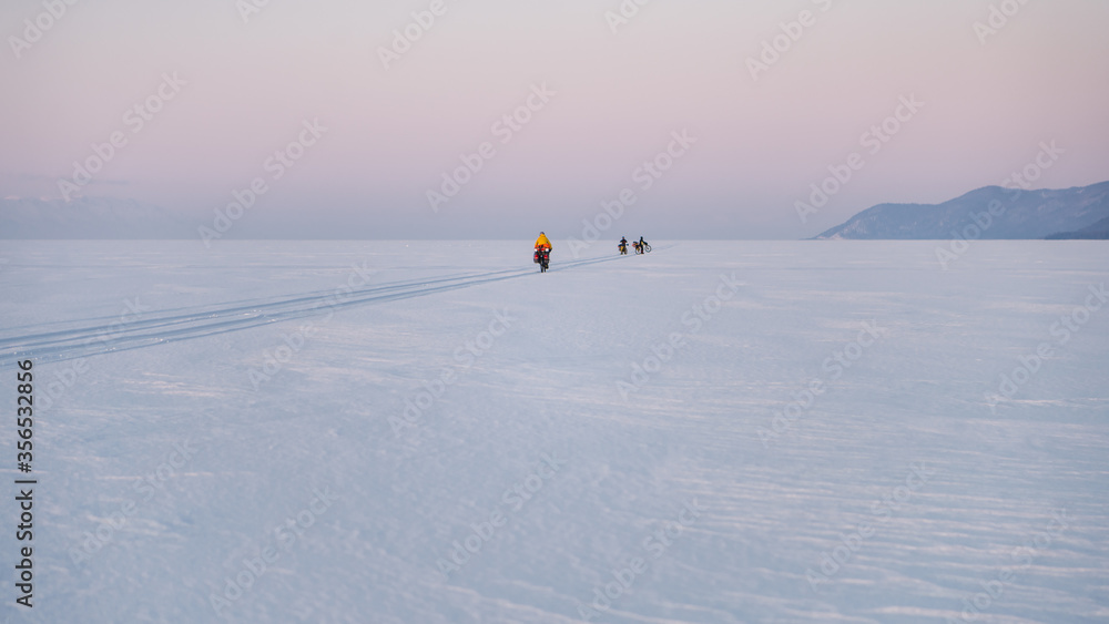 Fototapeta premium Byciclists on Baikal Lake in winter