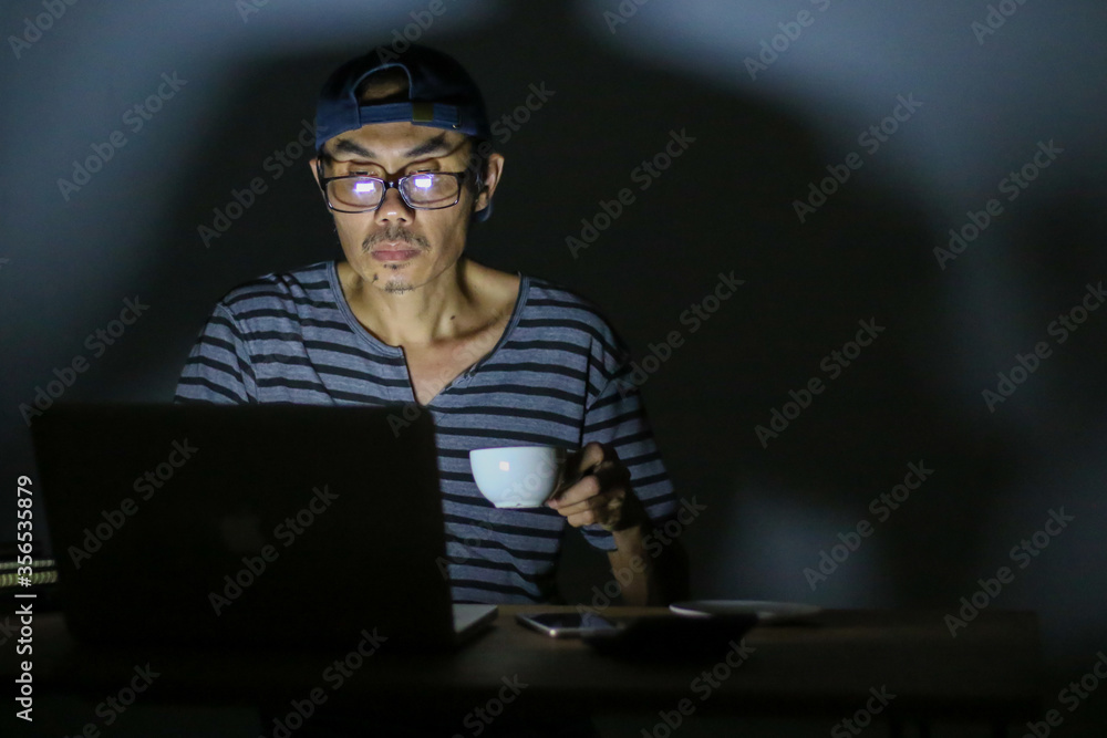 Asian man working late at home at night. Working from home concept. Asian man working late at home at night. Working from home concept.