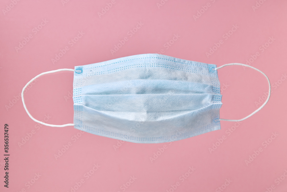 virus face mask protection medical equipment isolated on a pastel pink background. virus face mask protection medical equipment isolated on a pastel pink background.