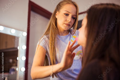 Makeup artist doing makeup for woman