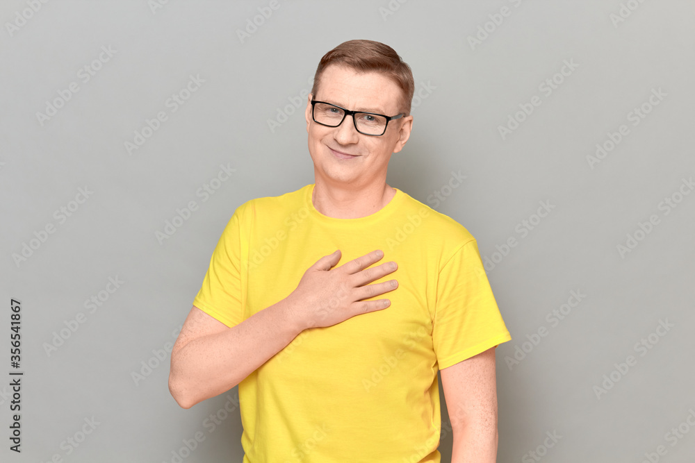 Portrait of man holding hand on chest and thanking somebody Portrait of man holding hand on chest and thanking somebody