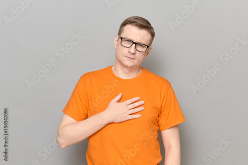 Portrait of man holding hand on chest and thanking somebody