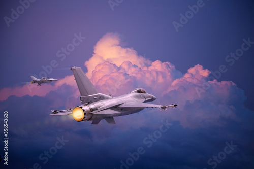F-16 Fighting Falcon jets (models) fly toward pink and purple clouds at sundown photo
