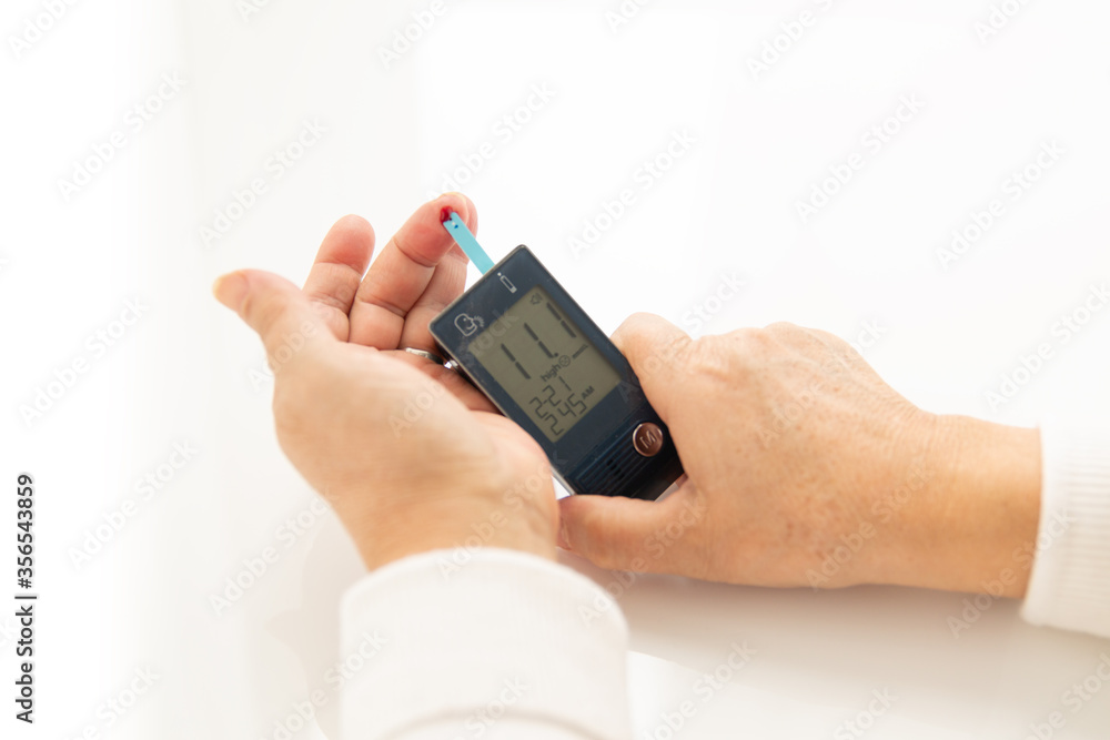 hands checking blood glucose level with Glucometer hands checking blood glucose level with Glucometer