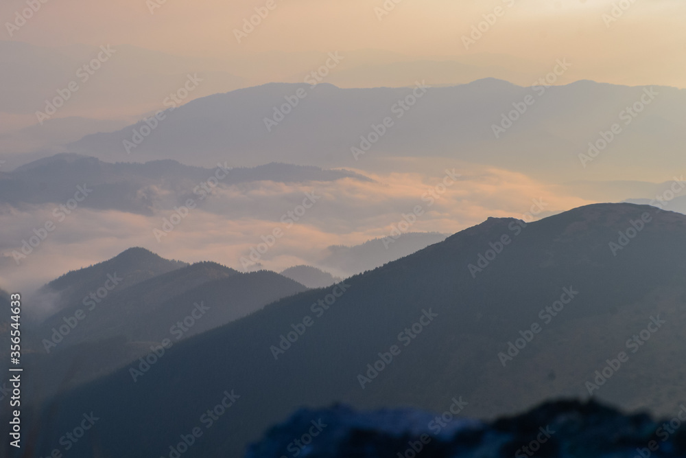 Beautiful sunrise view of landscape of mountains, forest and meadows in the Carpathians in sunny  cloudy weather