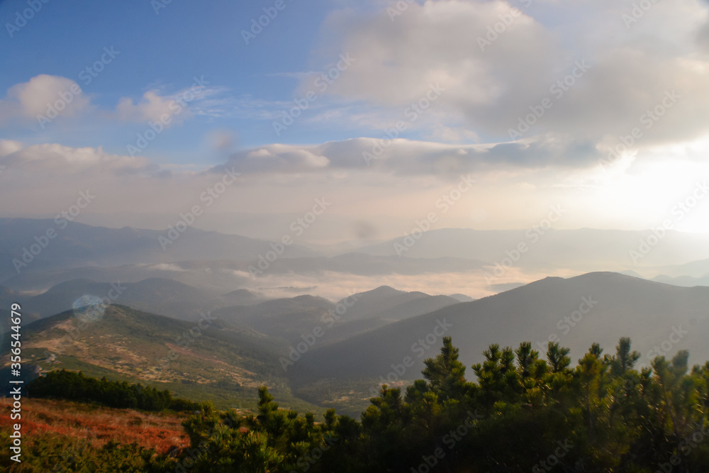 Beautiful sunset view of landscape of mountains, forest and meadows in the Carpathians in sunny cloudy weather Beautiful sunset view of landscape of mountains, forest and meadows in the Carpathians in sunny cloudy weather