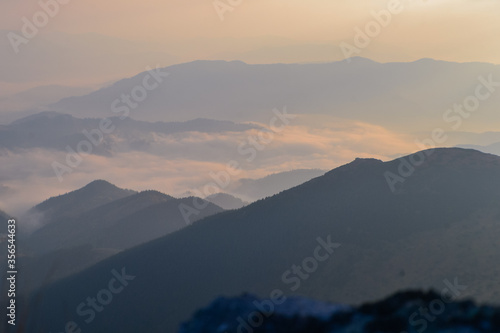 Beautiful sunrise view of landscape of mountains, forest and meadows in the Carpathians in sunny cloudy weather