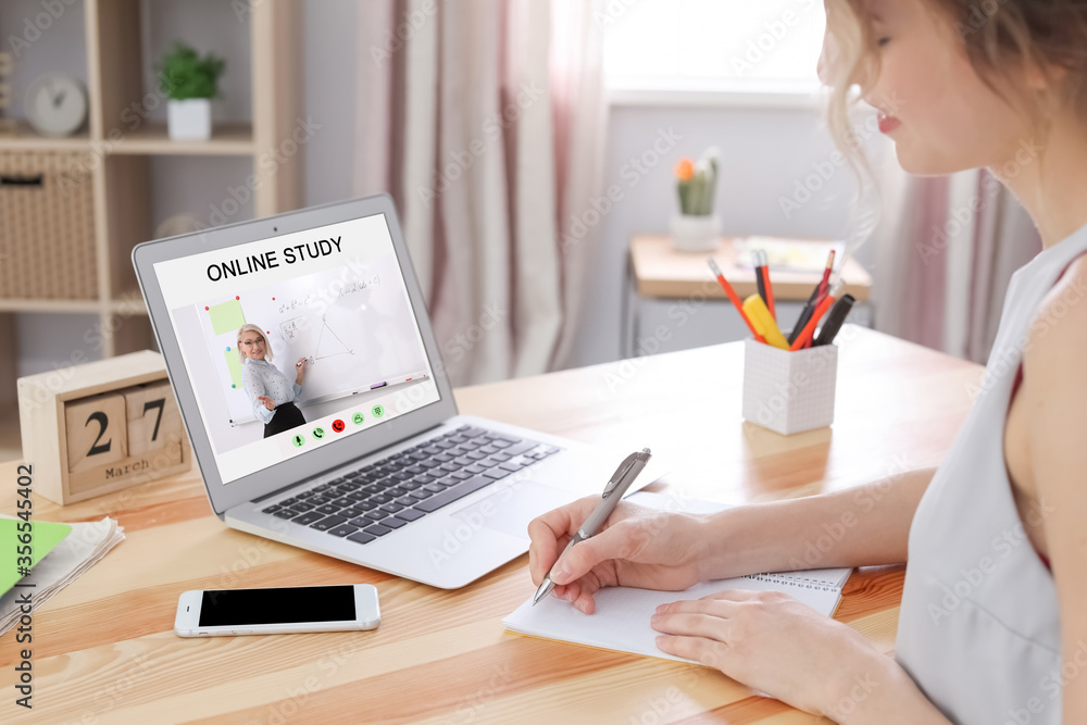 Fototapeta premium Young woman using laptop for online studying at home, closeup