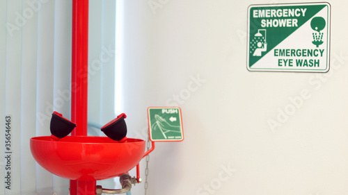 Eye wash station and push on button for flowing the water washing eyes, when touch with Acid or toxic chemical, safety first protection equipment in chemistry laboratory. Isolated in white background.