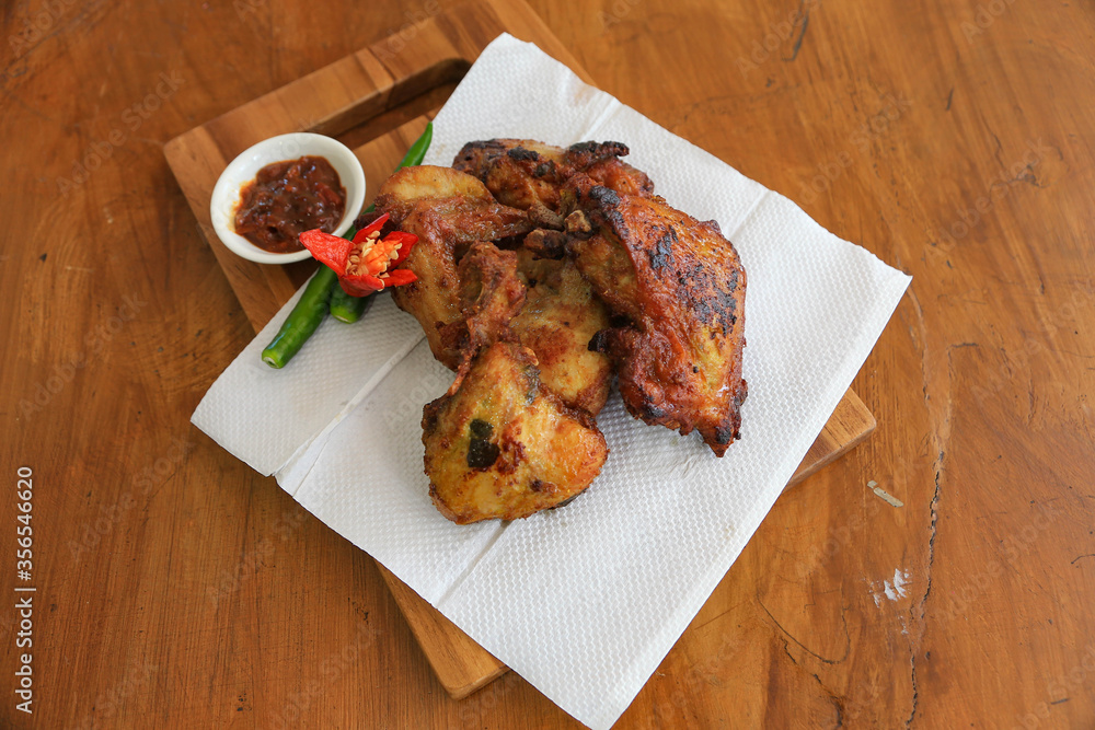 Photo of fried chicken food served with hot chili sauce and decorated with tomatoes and green chili Photo of fried chicken food served with hot chili sauce and decorated with tomatoes and green chili